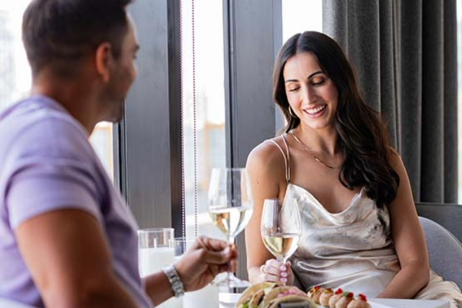 man and woman eating dinner by window